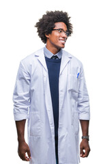 Fototapeta premium Afro american doctor scientist man over isolated background looking away to side with smile on face, natural expression. Laughing confident.