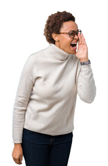 Young beautiful african american woman wearing glasses over isolated background shouting and screaming loud to side with hand on mouth. Communication concept.