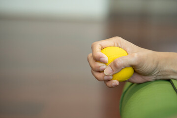 Hands of a woman squeezing a stress ball or yoga mat.