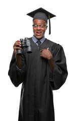 Young graduated african american man looking for a job using binoculars with surprise face pointing finger to himself