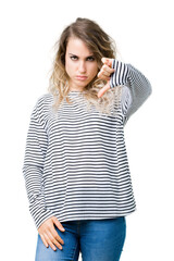 Beautiful young blonde woman wearing stripes sweater over isolated background looking unhappy and angry showing rejection and negative with thumbs down gesture. Bad expression.