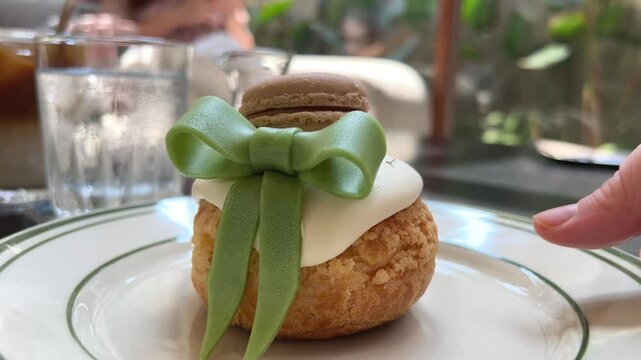 dessert with green bow and macaroon cake custard inside eclair