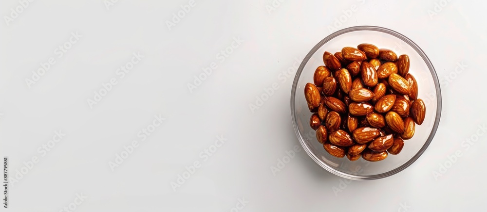 Poster caramel almonds in a glass bowl shot from above on a white background with clipping path ready for a