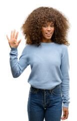 African american woman wearing a sweater showing and pointing up with fingers number five while smiling confident and happy.