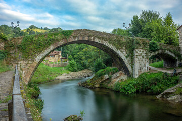 Obraz premium Medieval semicircular arch bridge over the Miera river, Liérganes, Cantabria, Spain, seen from the side