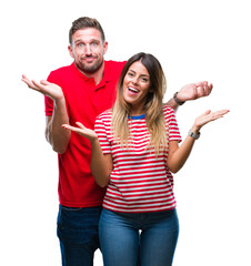 Young couple in love over isolated background clueless and confused expression with arms and hands...