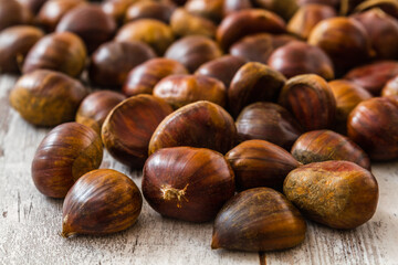 Chestnuts scattered on a rustic wooden table providing a natural and earthy touch perfect for...