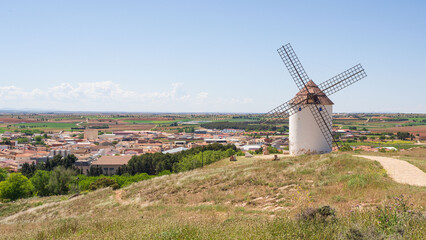 One traditional castilian windmill with a village in the background