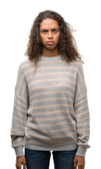 Beautiful young hispanic woman wearing stripes sweater skeptic and nervous, frowning upset because of problem. Negative person.