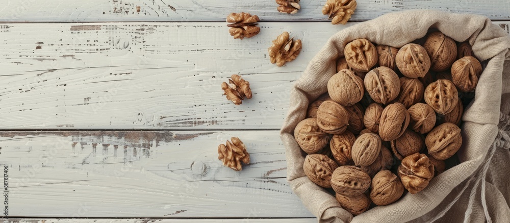 Poster walnuts arranged on a white wooden surface closed nuts in a cotton bag peeled kernels on a table hig