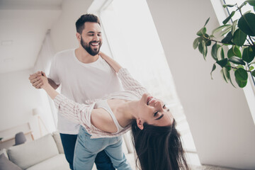 Photo of two idyllic partners spend pastime dance modern bright interior weekend flat indoors