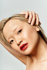 Naklejka premium An attractive Asian woman wearing vibrant clothes, flaunting red lipstick on her face.