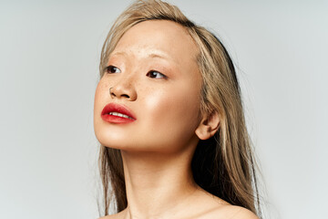 Naklejka premium An alluring Asian woman with long hair and red lipstick strikes a pose in vibrant attire.
