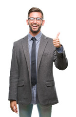 Young handsome business man over isolated background doing happy thumbs up gesture with hand. Approving expression looking at the camera with showing success.