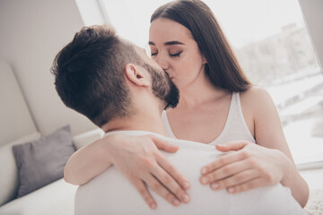 Photo of positive passionate couple dressed casual clothes kissing relaxing home indoors house apartment room