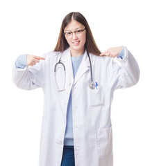 Young Chinese doctor woman over isolated background looking confident with smile on face, pointing...