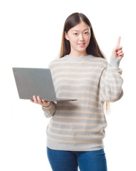 Young Chinese woman over isolated background using computer laptop surprised with an idea or question pointing finger with happy face, number one