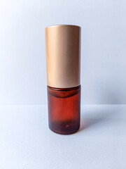 brown gold cosmetic glass pump bottle on isolated white background