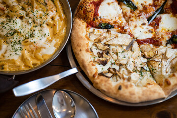 a pizza is topped with slices of chicken, cheese, and green leaves