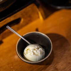 a single scoop of vanilla ice cream in a small bowl