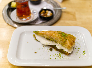 a slice of baklava on a white rectangular plate