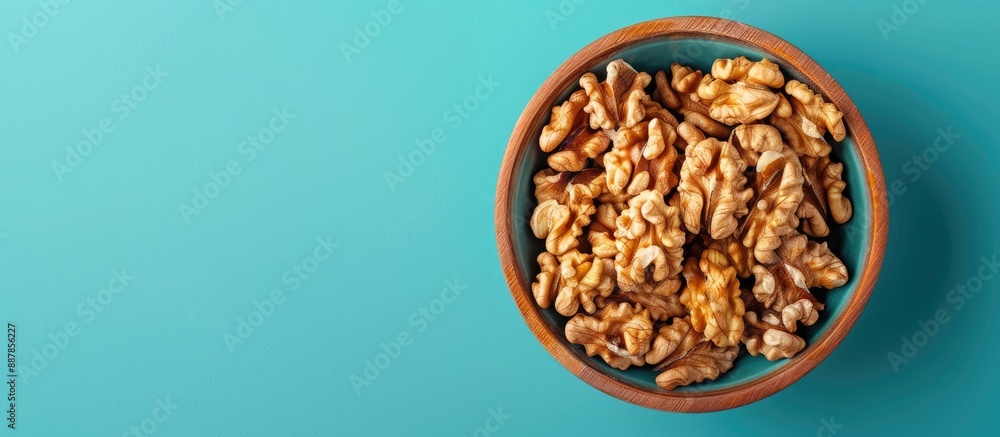 Poster close up from above of walnut kernel halves in a wooden bowl on a colored background depicting a hea