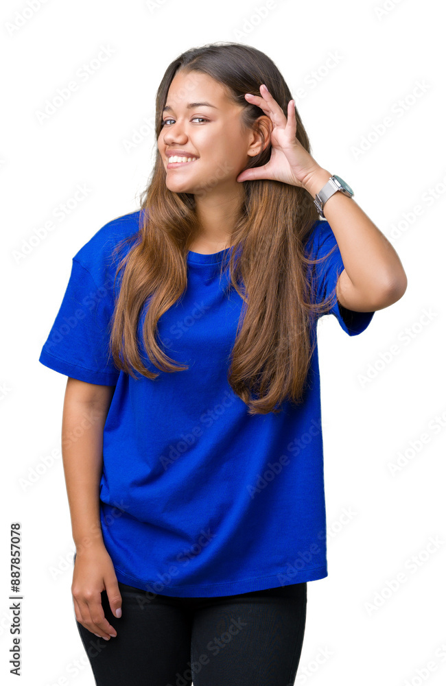 Poster Young beautiful brunette woman wearing blue t-shirt over isolated background smiling with hand over ear listening an hearing to rumor or gossip. Deafness concept.