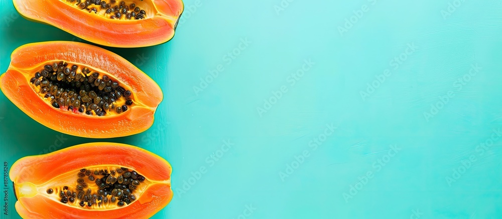 Aufkleber ripe papaya fruits on a light turquoise backdrop with a flat lay presentation and a copy space image