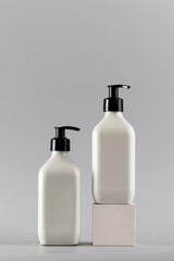 Two white dispensers with cosmetics with a place for the logo. Skin care