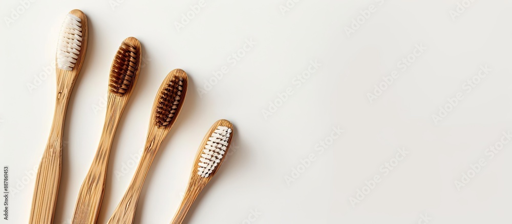 Aufkleber dental care concept featuring three bamboo toothbrushes arranged on a white backdrop from a top view