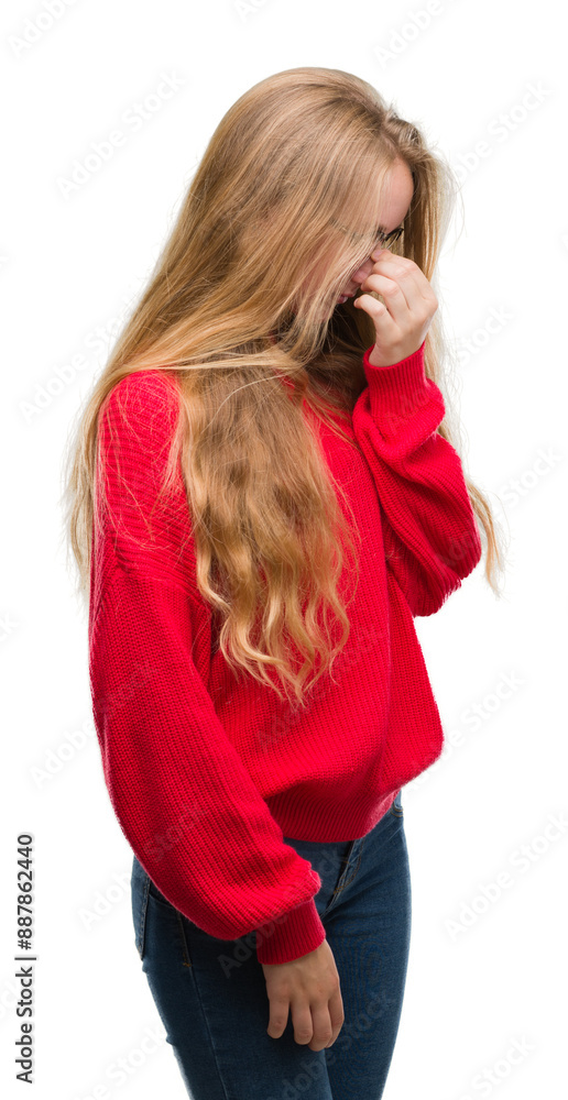 Sticker blonde teenager woman wearing red sweater tired rubbing nose and eyes feeling fatigue and headache. 