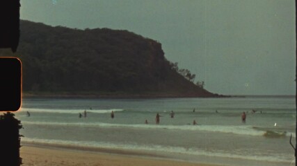 Super 8 film vintage of people swimming enjoying ocean waves summer at Durras Beach headland coastline South Coast Australia light leaks retro travel tourism