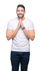 Young man wearing casual white t-shirt over isolated background praying with hands together asking for forgiveness smiling confident.