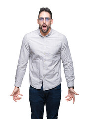 Fototapeta premium Young handsome man wearing sunglasses over isolated background afraid and shocked with surprise expression, fear and excited face.