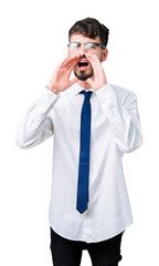 Young handsome business man wearing glasses over isolated background Shouting angry out loud with hands over mouth