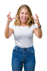 Beautiful young woman wearing casual white t-shirt over isolated background Shouting frustrated with rage, hands trying to strangle, yelling mad