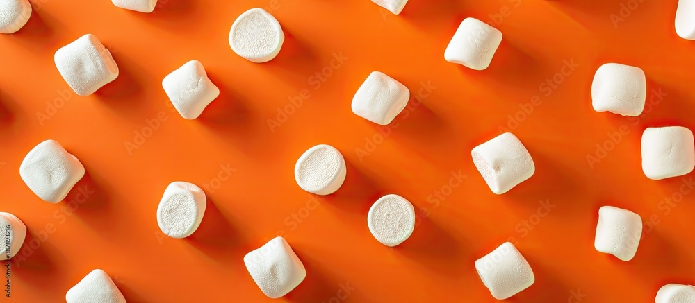 Poster Top down perspective displaying delectable marshmallows arranged in circles set against an orange background with ample copy space image