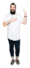 Young hipster man with long hair and beard wearing casual white t-shirt Swearing with hand on chest...