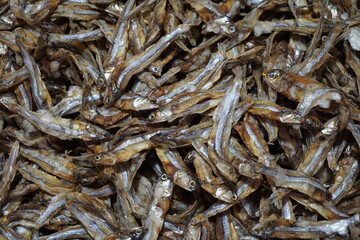 A pile of dried anchovies displayed in a fish market, Little dried fish in an Asian fish market, Fresh dried sardines and anchovies being displayed for selling at a seafood market