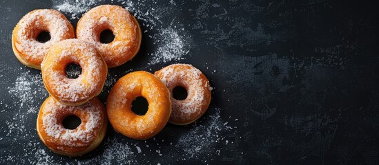 Naklejka premium A picture of Berliner donuts with glaze on a black backdrop showcasing a delicious treat against a dark copy space image