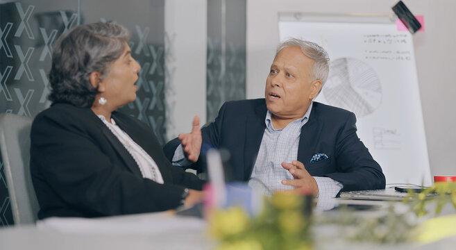 Indian Asian old gen x aged angry sad man woman sitting do team work talk argue scold yell fail client deal job office place elder upset boss male tired older female fight money loss bad crisis claim