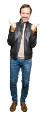 Obraz premium Middle age handsome man wearing black leather jacket success sign doing positive gesture with hand, thumbs up smiling and happy. Looking at the camera with cheerful expression, winner gesture.