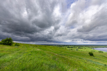 A cloudy sky with a field of grass in the background