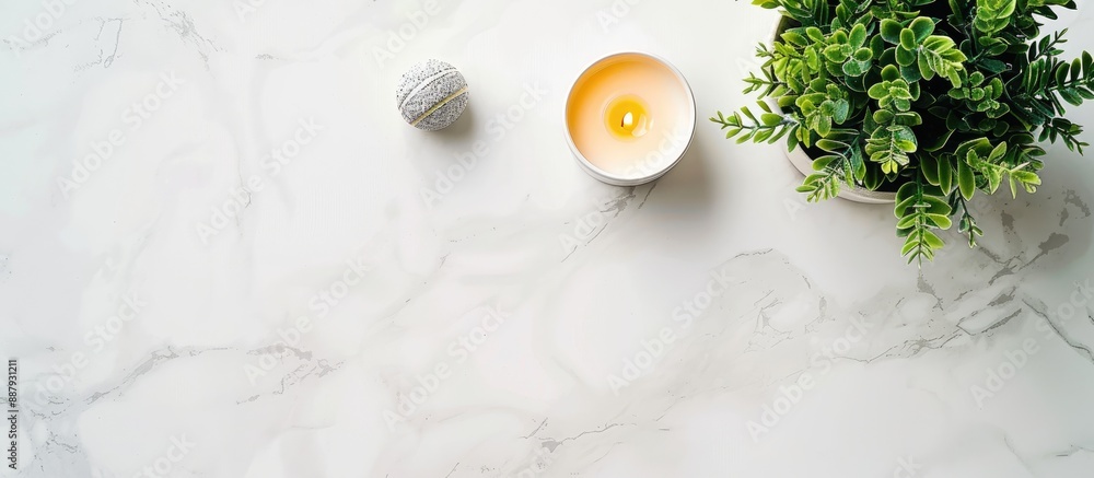 Poster modern work desk with a plant candle on a white marble background seen from above providing space fo