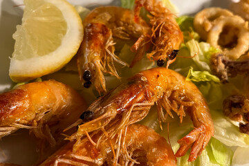 Grilled shrimp with lemon, garlic and white sauce on a plate at an Italian restaurant. Seafood
