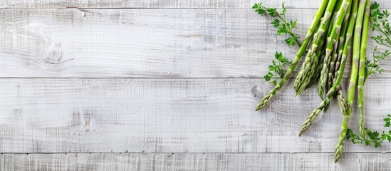 Fresh green asparagus sprouts on a white wooden surface with copy space image