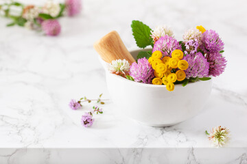 medical flowers herbs in mortar, alternative medicine. clover milfoil tansy rosebay
