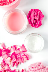 Nail care spa set with rose blossom, cream white background top view