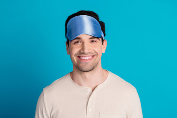 Portrait of nice young man beaming smile wear pajama isolated on blue color background