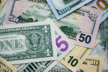 Big amount of US dollar bills in different nominations on table. Many dollar banknotes under natural light